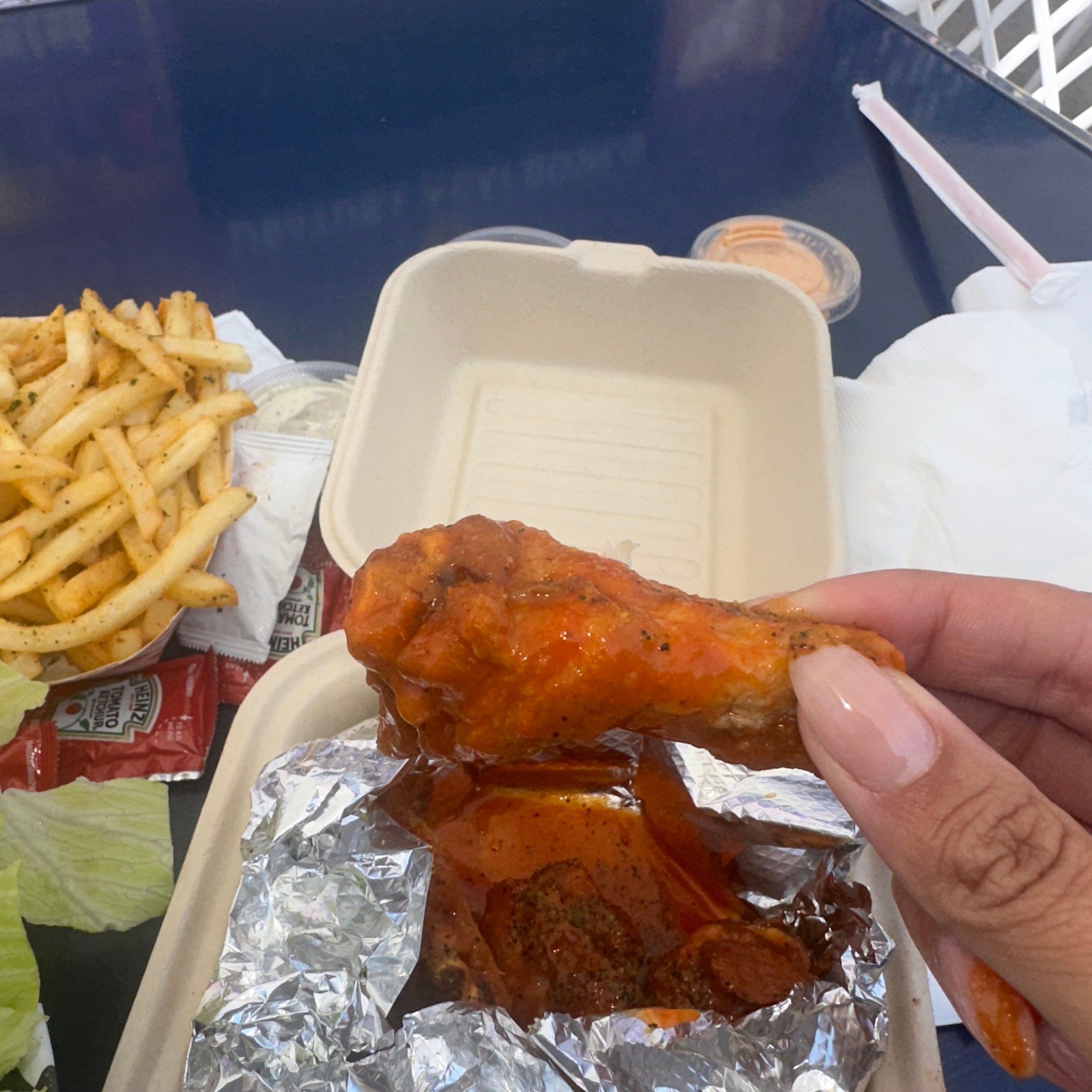 Hand holding wing from Marathon Burger in Venice