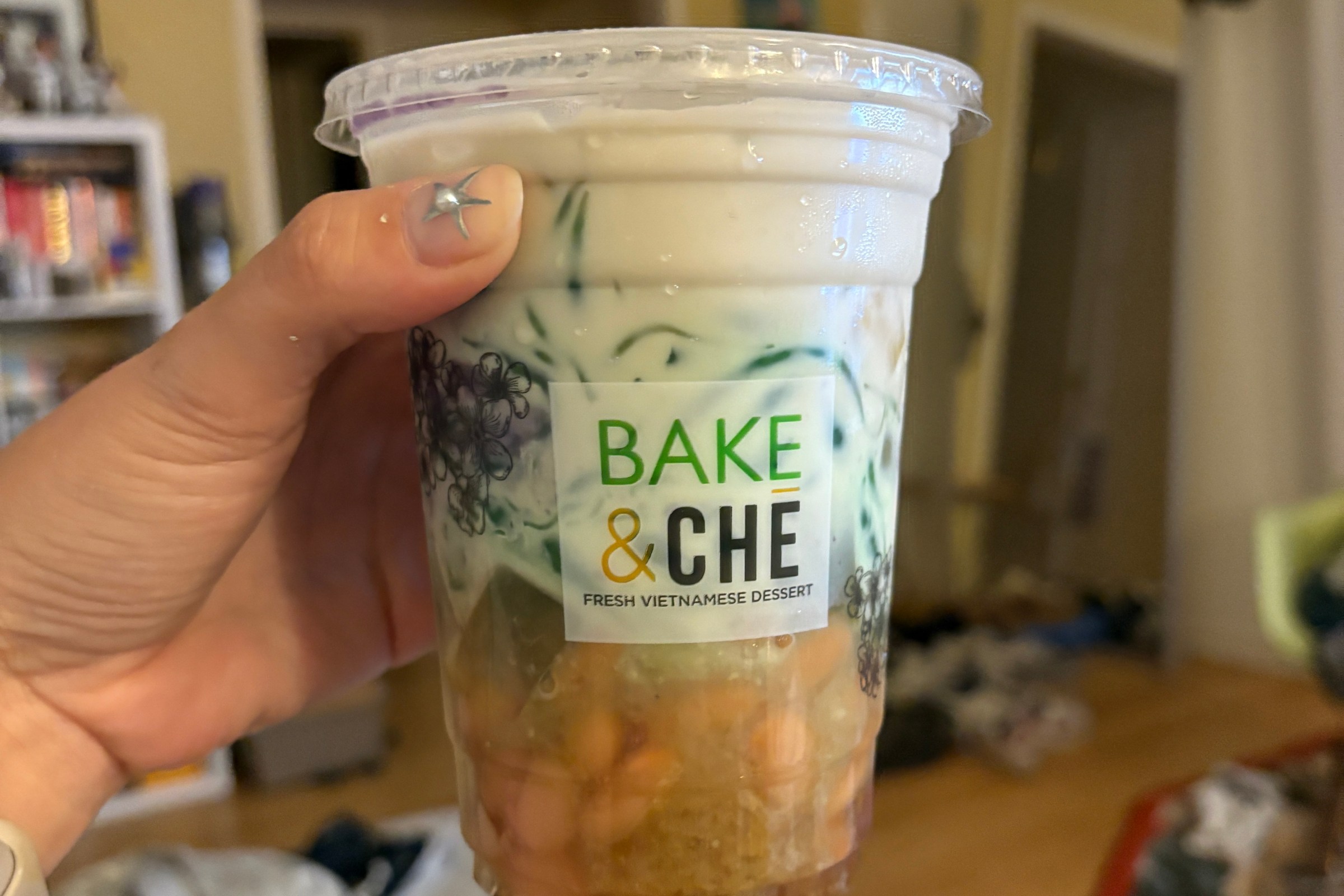 Hand holding che from Bake & Che, a sweet dessert with jackfruit, pandan, and more