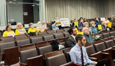 Community members hold signs urging the county to replace the current trash incinerator at a County Council work session on Jan. 28, 2025.