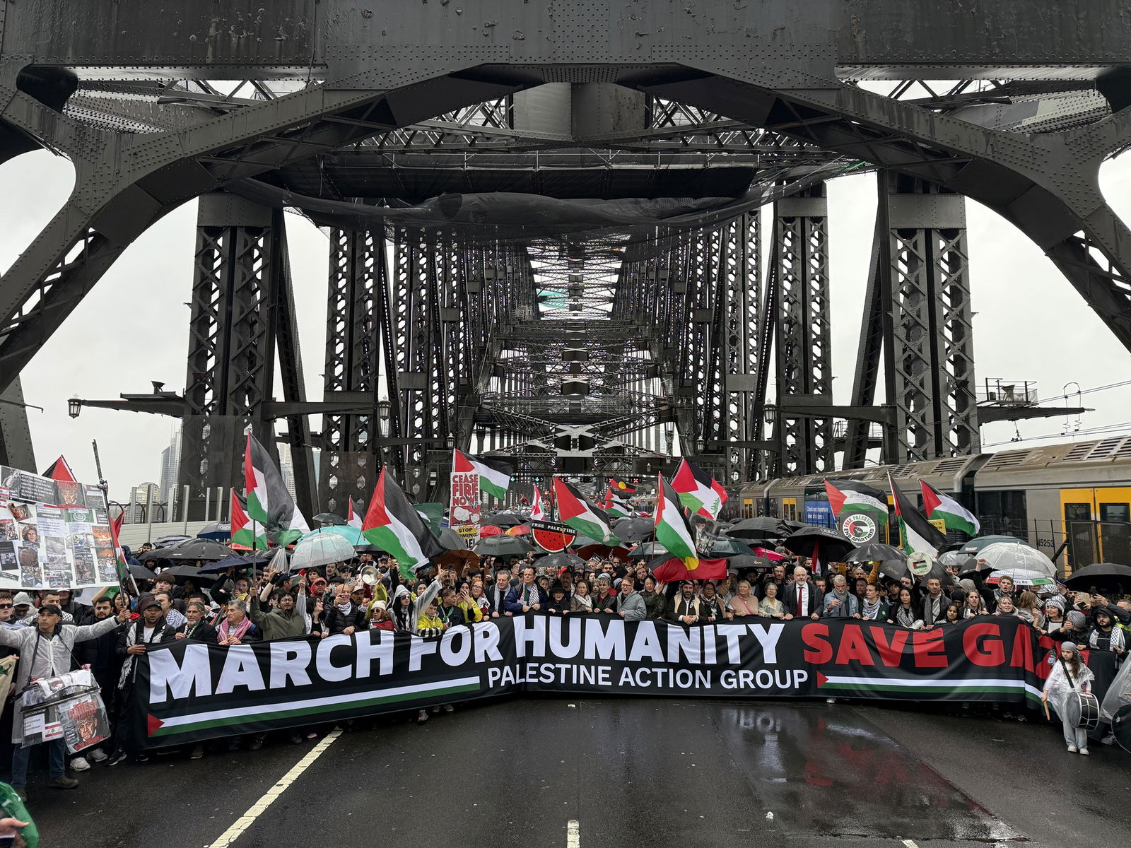 Protesters hold a banner that reads 'MARCH FOR HUMANITY SAVE GAZA' across the habour bridge
