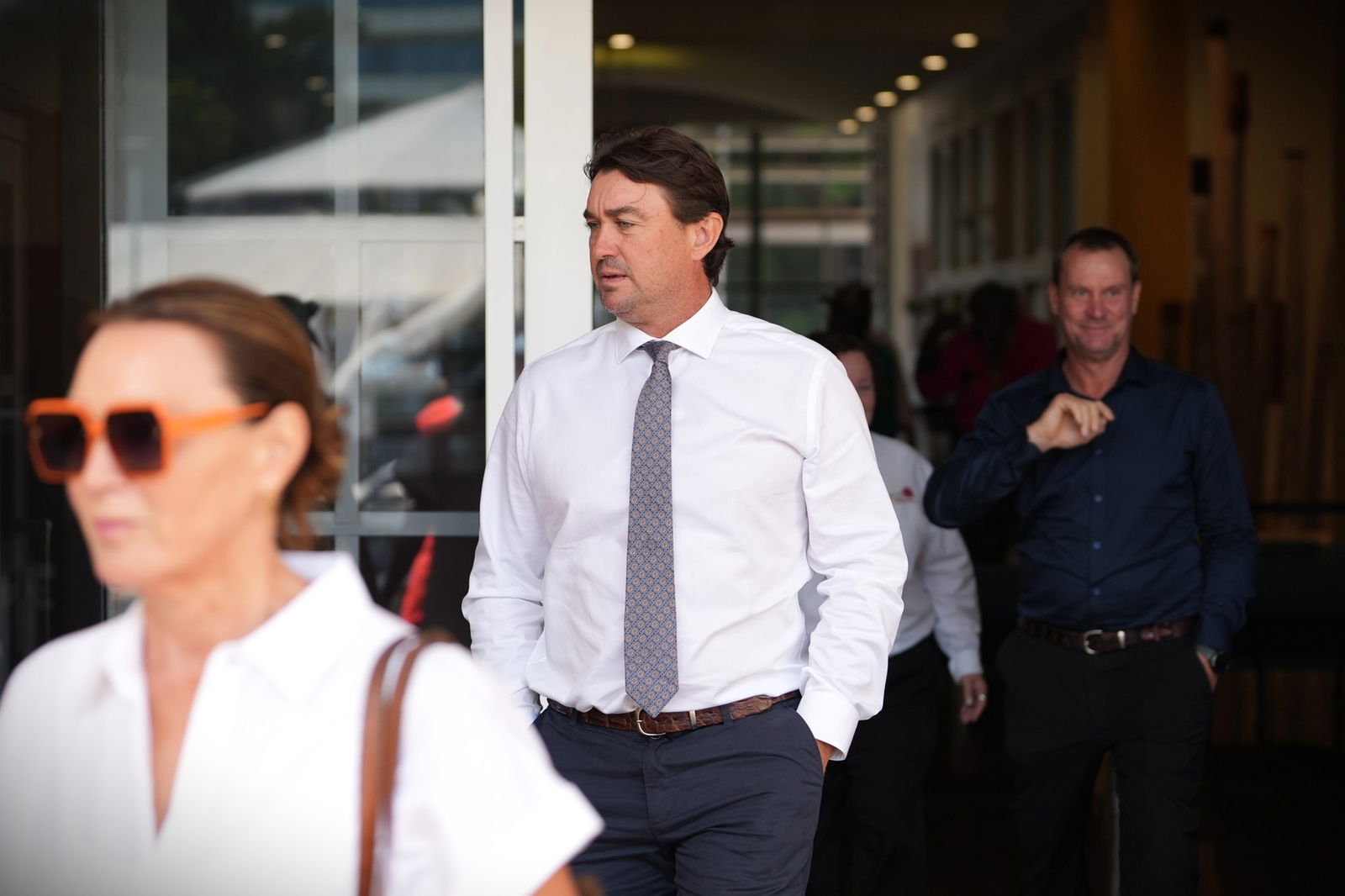 A man wearing a tie, walking out of court.