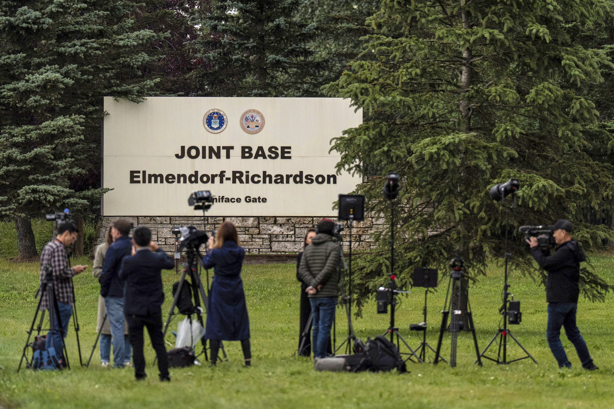 Members of the media stand outside base