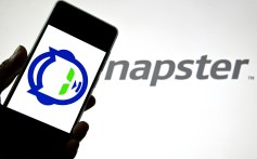 In this photo illustration, a Napster logo is seen displayed on a smartphone and in the background.