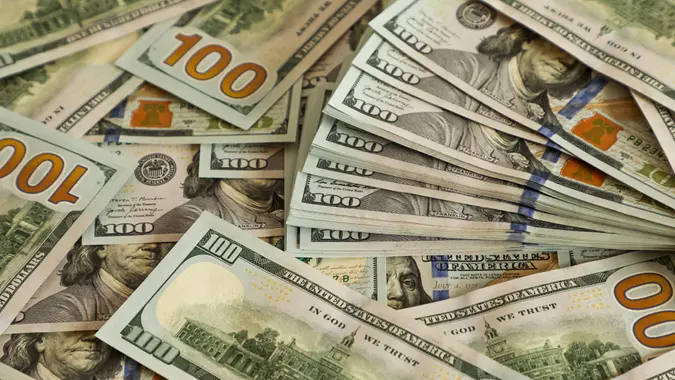 Stacks of 100 US dollar bills scattered closely together. Concept of wealth, financial success, banking, investment, income, and economic prosperity. stock photo