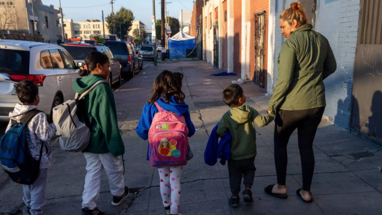 Nubia Reyes walks with her son and other migrant children to school on Skid Row in Los Angeles. (Los Angeles Times/Brian van der Brug)