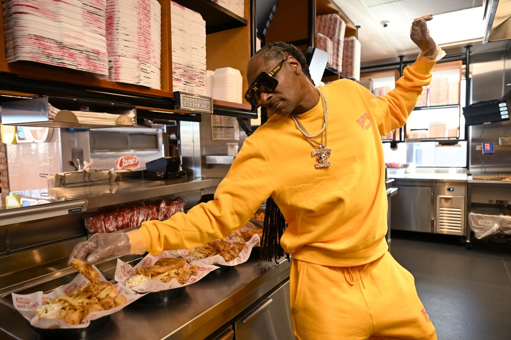 Snoop Dogg working at a Raising Cane's restaurant.