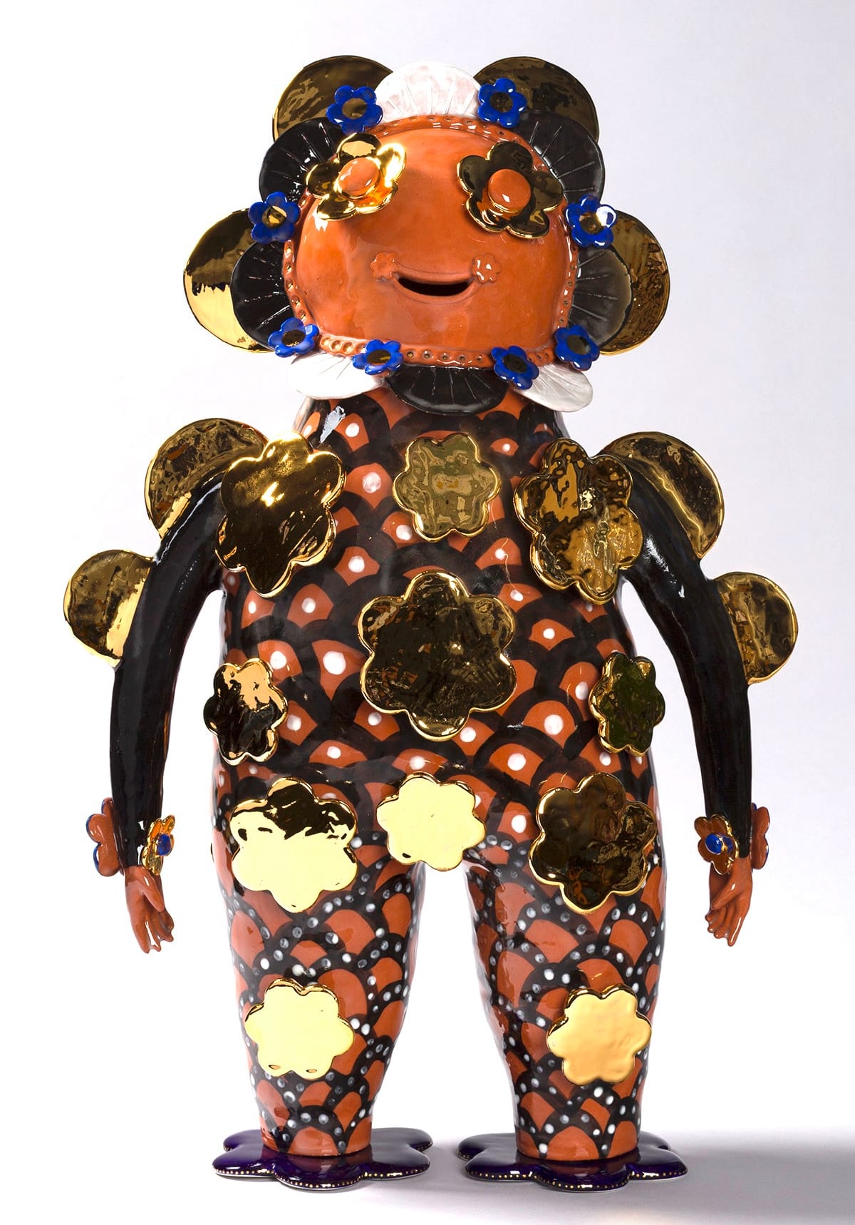 a terracotta figure with black and gold flowers on its body