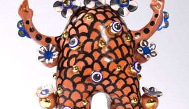 a terracotta figure with flowered patterns and peace sign hands