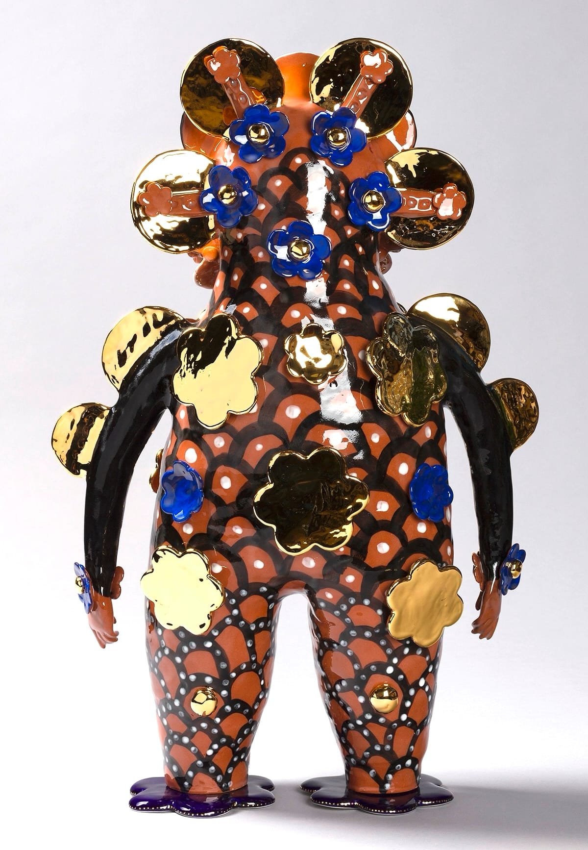 a terracotta figure with black and gold flowers on its body