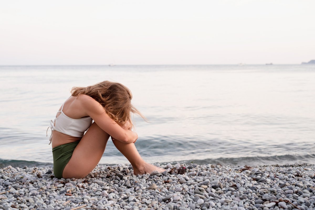 Stock image of sad woman on beach.