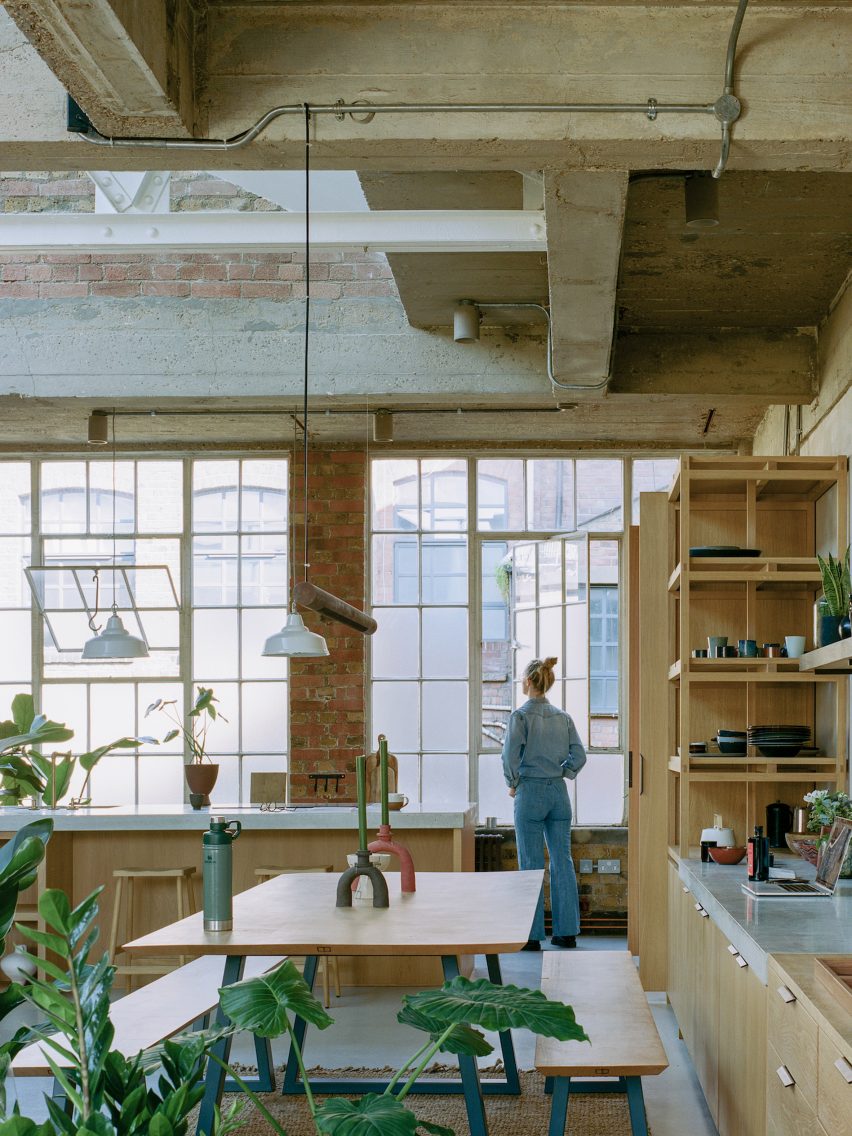 Open-plan kitchen with concrete ceiling and brick wall at Earthrise Studio by Studio McW