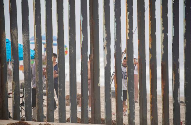 Beach goers on the Tijuana side seen from the beach at Border Field State Park on Sunday. (Alejandro Tamayo / The San Diego Union-Tribune)