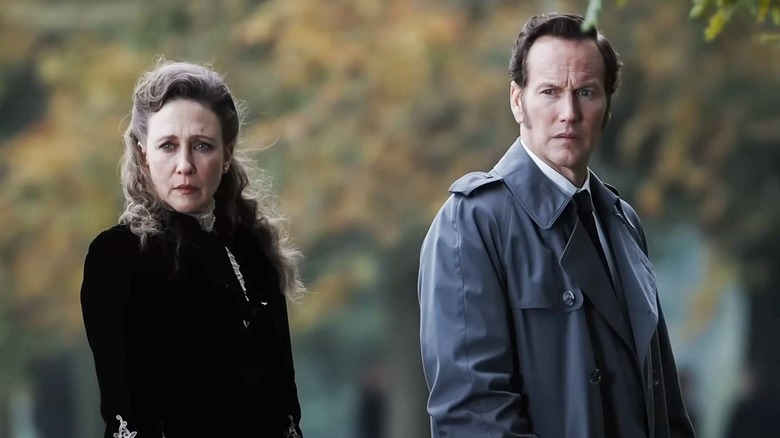 Vera Farmiga and Patrick Wilson as Lorraine and Ed Warren in The Conjuring: Last Rites, looking intently at something out of frame.