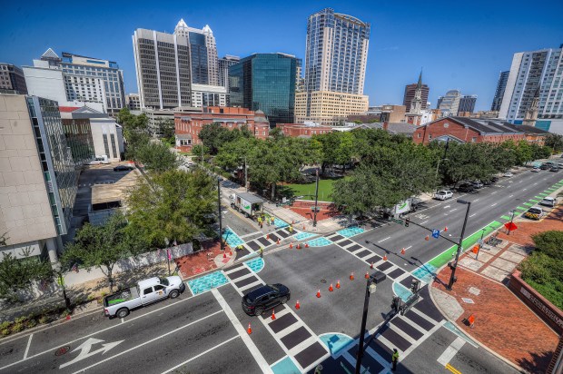 Contractors cover art on the crosswalk at the intersection of South Rosalind Avenue and East Jackson Street in downtown Orlando, on Wednesday, Aug. 27, 2025. (Ricardo Ramirez Buxeda/Orlando Sentinel)