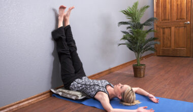 Woman performing legs up the wall yoga pose in domestic setting