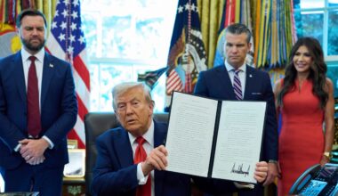 President Donald Trump holds up an executive order on cashless bail as Vice President JD Vance, from left, Defense Secretary Pete Hegseth and Homeland Security Secretary Kristi Noem look on in the Oval Office of the White House, Monday, Aug. 25, 2025, in Washington. (AP Photo/Evan Vucci)