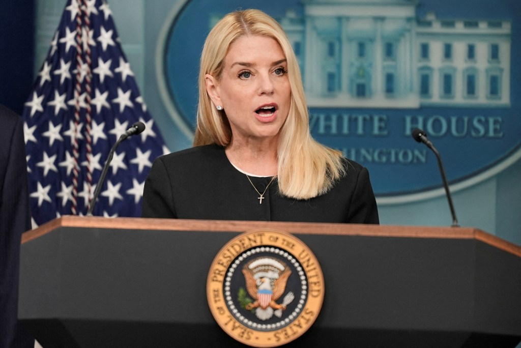 Pam Bondi speaking at a podium at the White House.