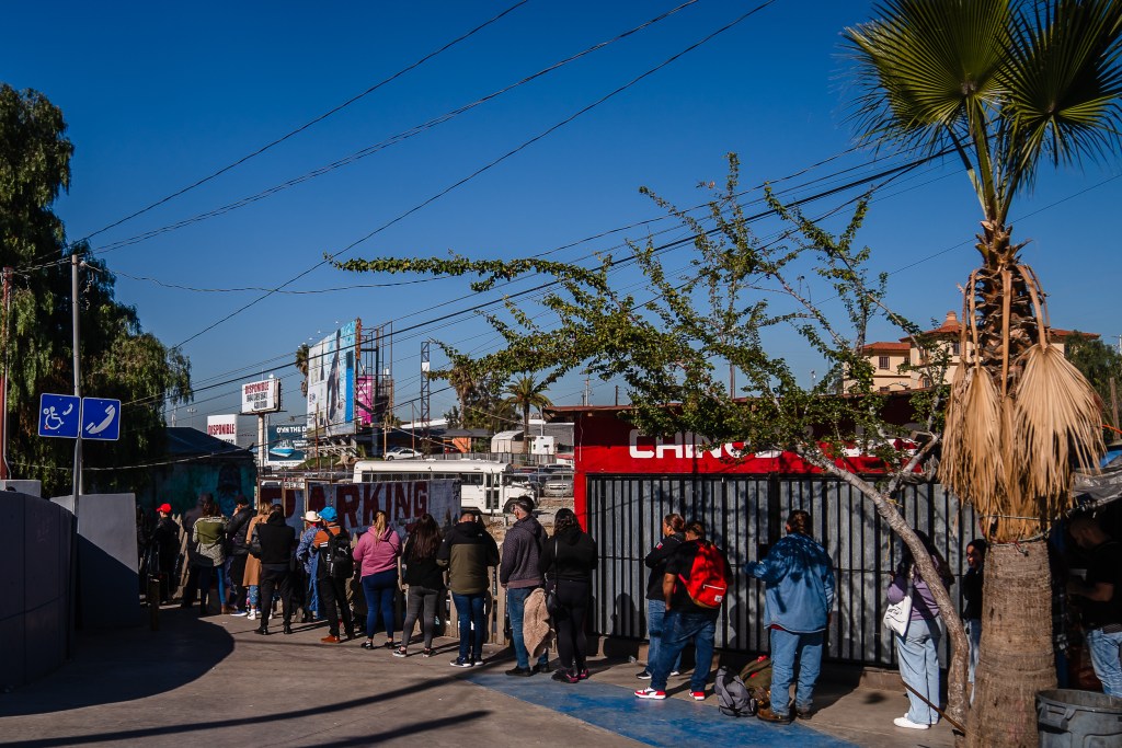 People wait in a long line border crossing to enter the United States from Tijuana on Dec. 21, 2022.