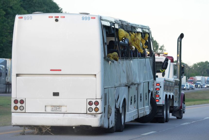 The tour bus is towed away for investigation Friday.