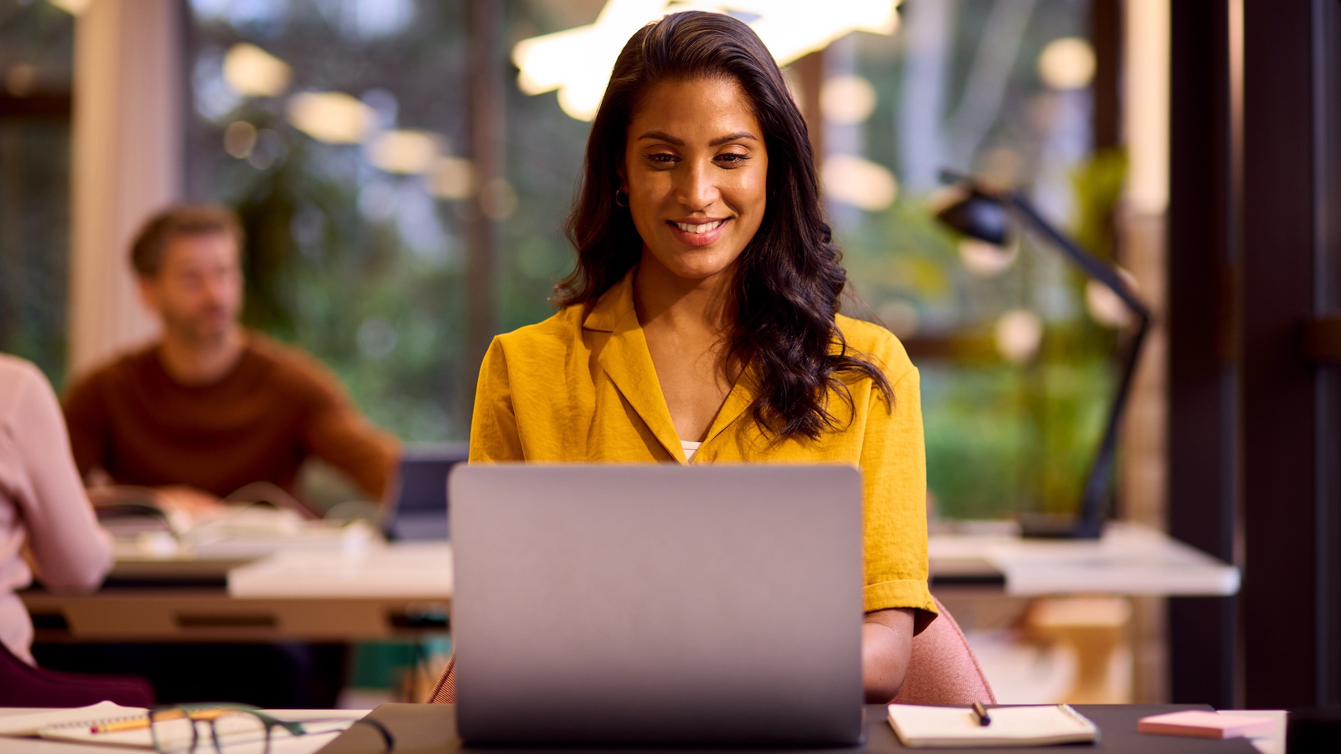 A young woman looking happy at her Windows 10 laptop