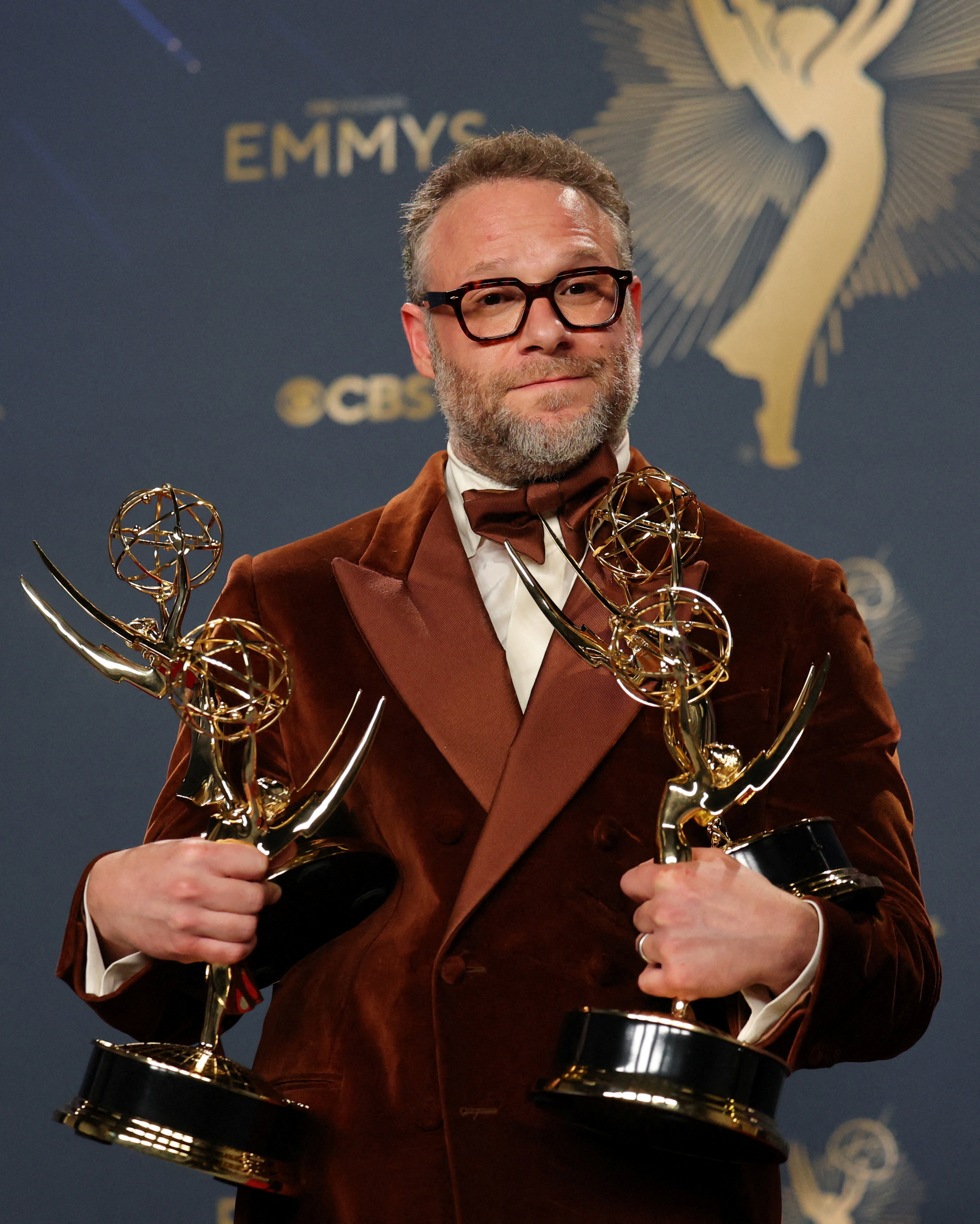 Seth Rogen holding four Emmy Awards for "The Studio".