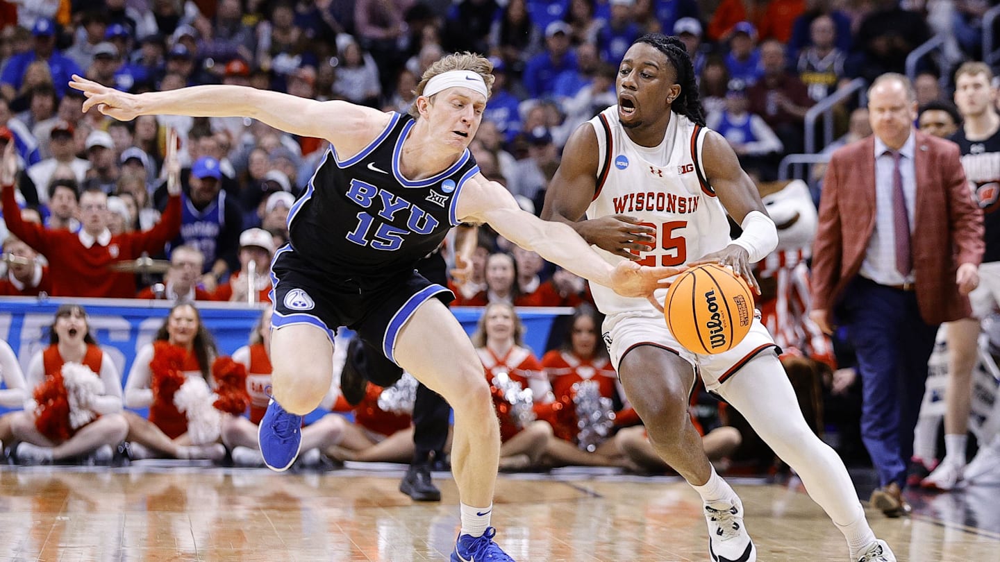 Mar 22, 2025; Denver, CO, USA; Wisconsin Badgers guard John Blackwell (25) dribbles the ball past Brigham Young Cougars forward Richie Saunders (15) during the first half in the second round of the NCAA Tournament  at Ball Arena. Mandatory Credit: Isaiah J. Downing-Imagn Images
