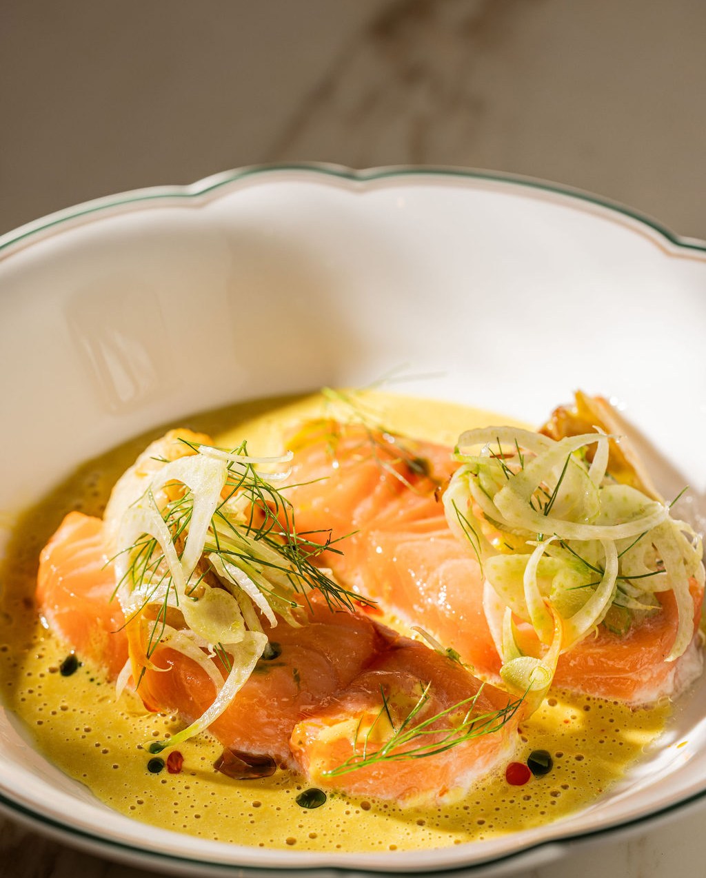 Salmon sits in on top of a green sauce. 
