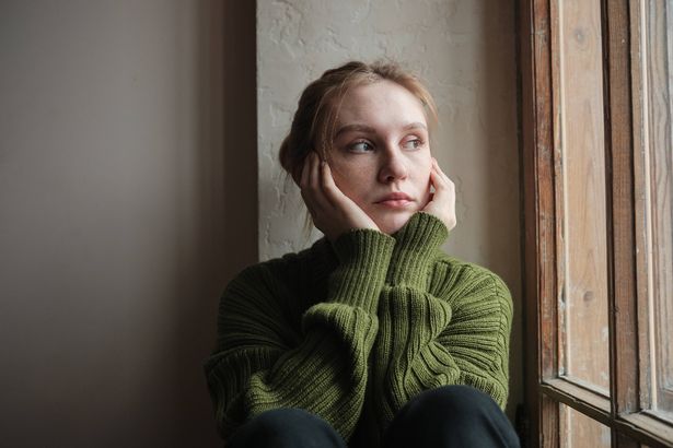 Sad girl looking out window