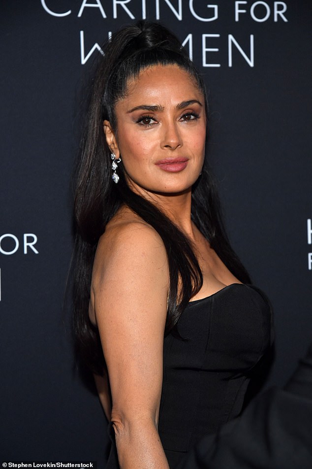 Her long dark locks were pulled back away from her face and styled into a sleek half up do, allowing strands to flow down past her shoulders