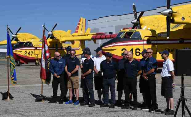 The crew of Québec pose in front of Super Scoopers...