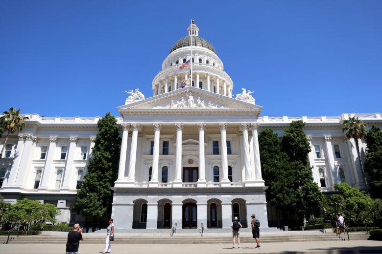 The California State Capitol building with a central dome and Corinthian columns under a clear blue sky.