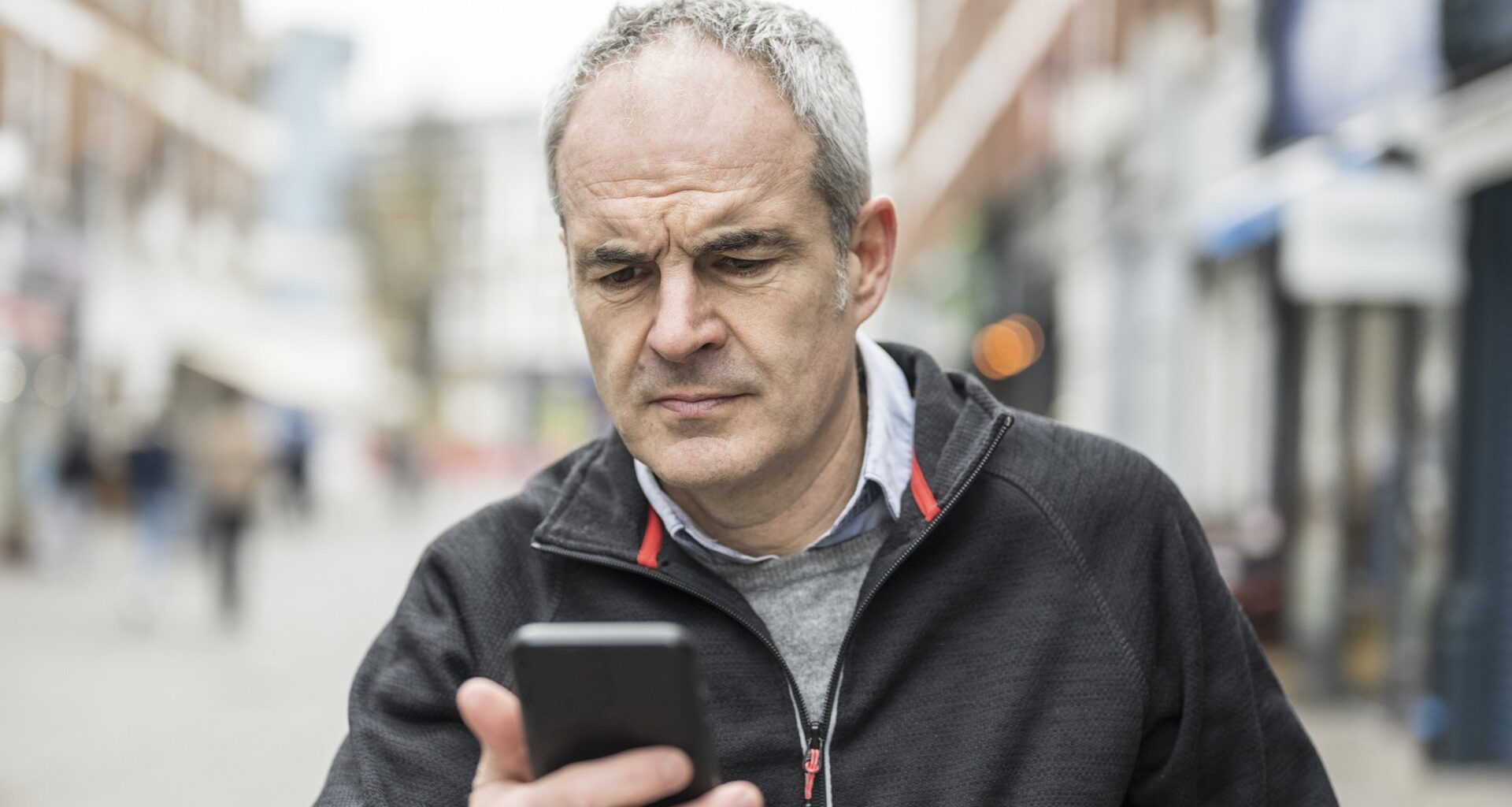 Mature man frowning with smart phone device problems stock photo