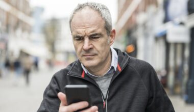 Mature man frowning with smart phone device problems stock photo