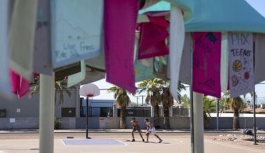 Edward Shephard, left, and Adrian Simpson play basketball near a temporary public art piece that provides shade at Sunnyslope Park in Phoenix, Saturday, Aug. 30, 2025. (AP Photo/Samantha Chow)