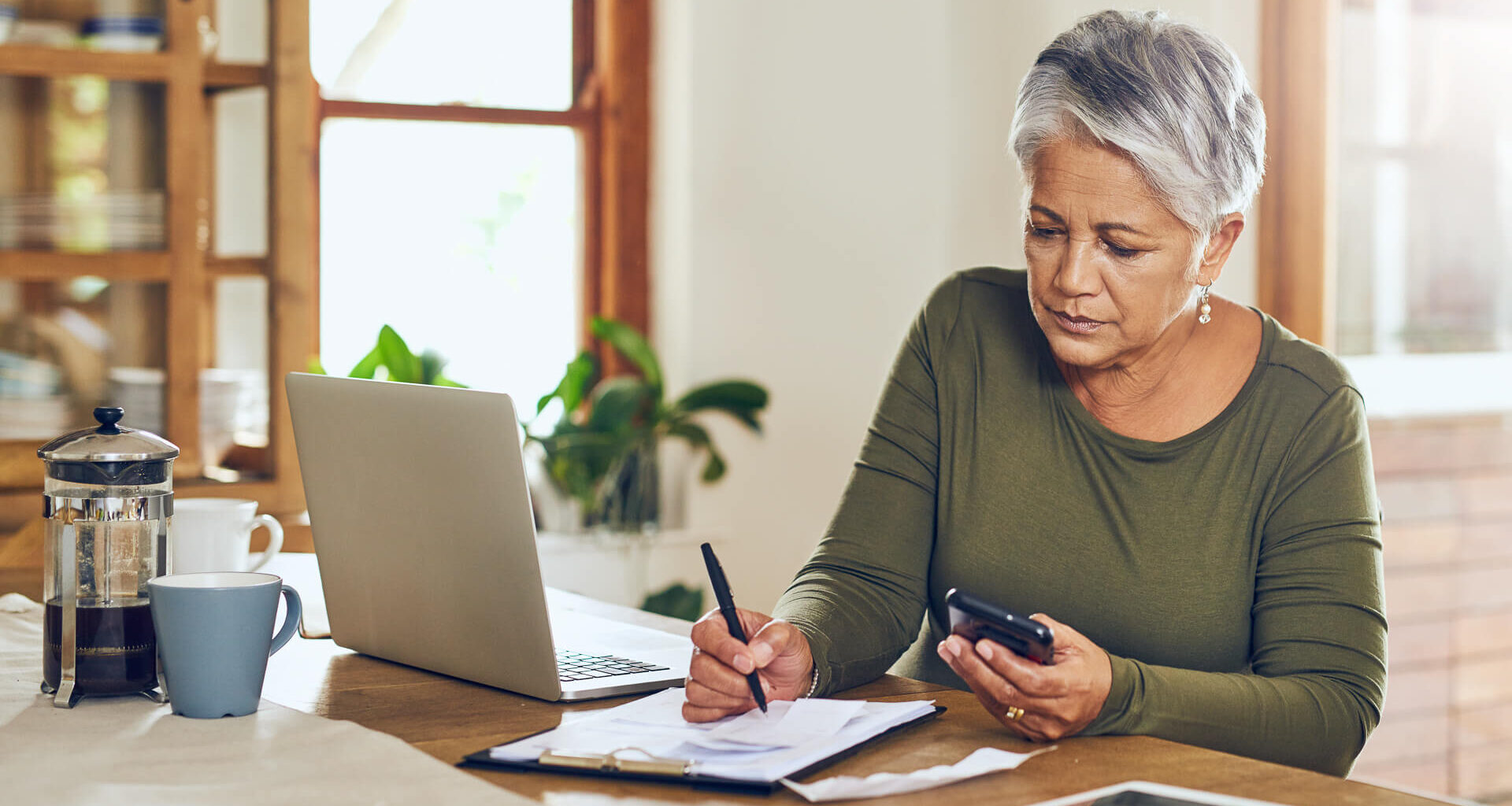 Shot of a mature woman going through paperwork at home.