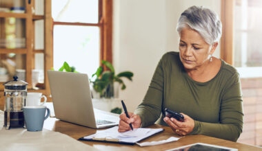 Shot of a mature woman going through paperwork at home.