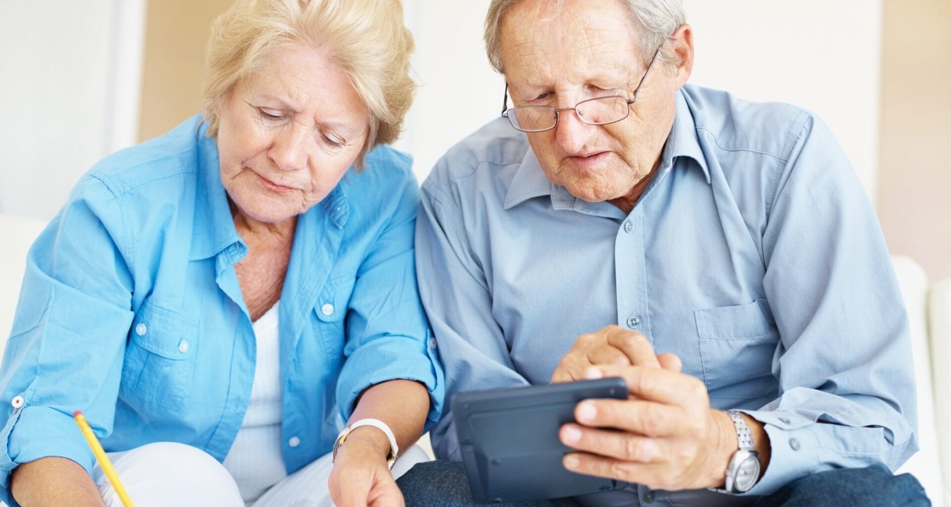 Portrait of a retired senior couple calculating their personal finances at home.