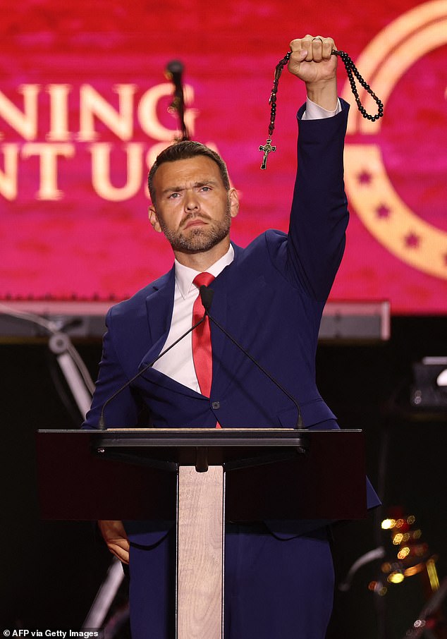 US political activist Jack Posobiec holds up a rosary as he speaks during the public memorial service for right-wing activist Charlie Kirk at State Farm Stadium in Glendale, Arizona, on September 21, 2025. (Photo by Patrick T. Fallon / AFP) (Photo by PATRICK T. FALLON/AFP via Getty Images)