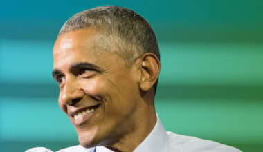 Former president Barack Obama smiling in a shot to illustrate his current wealth and net worth after politics.