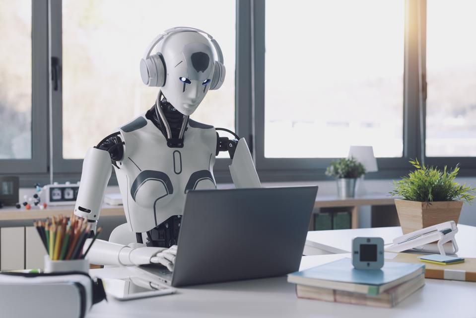 Robot working on a laptop, symbolizing AI-proof jobs for introverts.