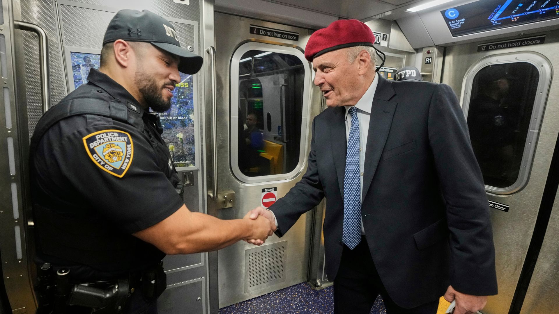 New York Mayor candidate Curtis Sliwa meets a New York City Police Department officer as he campaigns in the New York City subway system, Monday, Aug. 18, 2025.