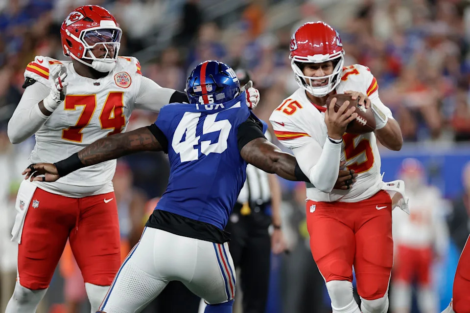 Kansas City Chiefs quarterback Patrick Mahomes (15) runs with the ball as New York Giants outside linebacker Tomon Fox (45) defends and Chiefs tackle Jawaan Taylor (74) watches during the first half of an NFL football game Sunday, Sept. 21, 2025, in East Rutherford, N.J. (AP Photo/Adam Hunger)