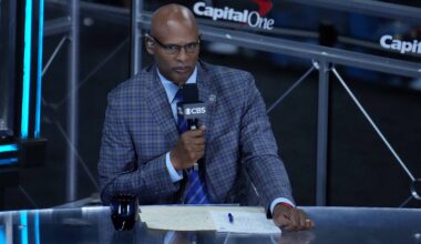CBS announcer Clark Kellogg holds the microphone during a game