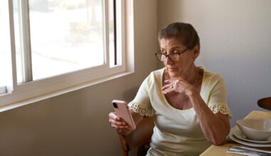 Woman sitting at a table and looking at her cell phone