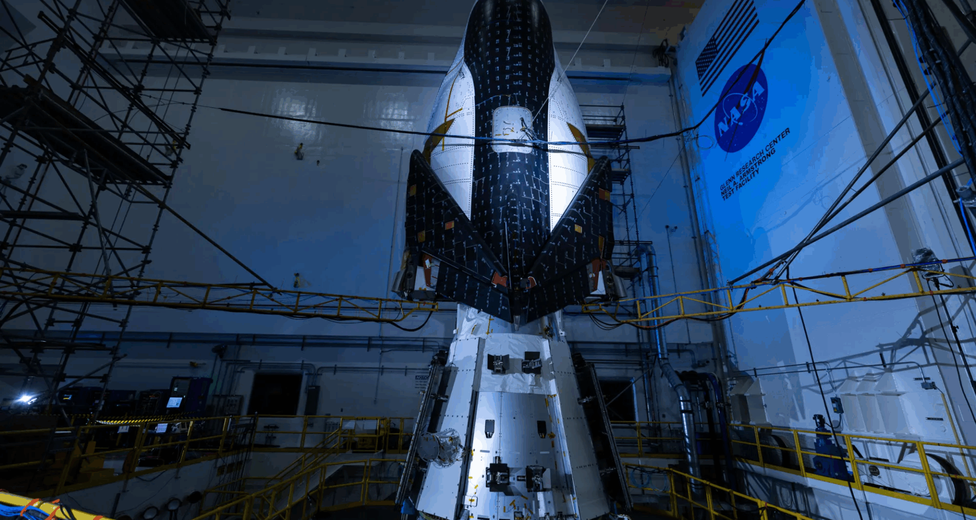 The Sierra Space Dream Chaser winged spacecraft is seen stacked atop its Shooting Star cargo module on the vibration table at NASA’s Armstrong Test Facility in Sandusky, Ohio, while undergoing testing to simulate launch and re-entry conditions.