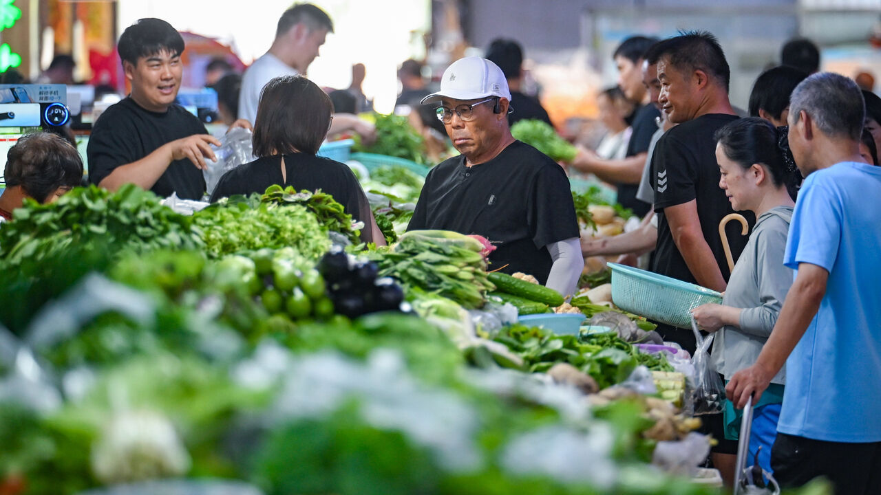 Customers purchase vegetables at an agricultural trade market in Nanjing, Jiangsu Province of China.