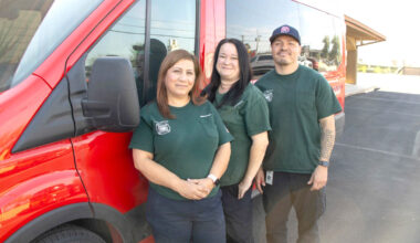 Mary Prado, left, and two other crisis intervention specialists with the Phoenix Community Assistance Program, which provides mental health specialists to respond to emergency calls instead of or in addition to police, pose for a photo in front of a van.