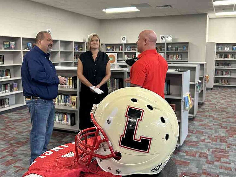 Mark Gottsponer, from left, a regional director for Dollar General, chats with Tara Herbert, library media specialist at Lingle Middle School, and Erik Sokol, the school's principal, in the renovated library space Thursday. Herbert applied for the Dollar General Literacy Foundation's $20,000 