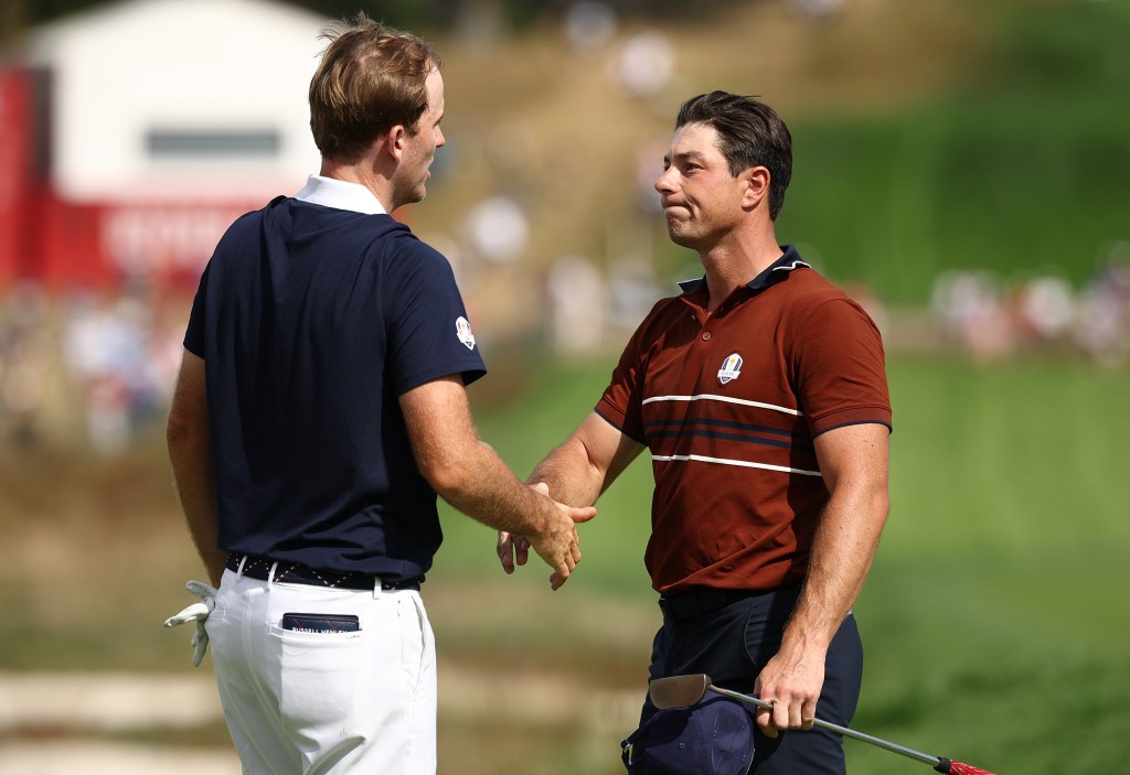 Russell Henley of Team United States and Viktor Hovland of Team Europe shake hands after Hovland and Robert MacIntyre of Team Europe defeated Henley and Scottie Scheffler of Team United States 1UP during the Saturday morning foursomes matches of the 2025 Ryder Cup at Black Course at Bethpage State Park Golf Course on September 27, 2025 in Farmingdale, New York.