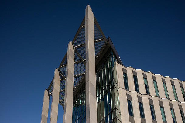 Outside of modern academic building featuring glass and limestone.